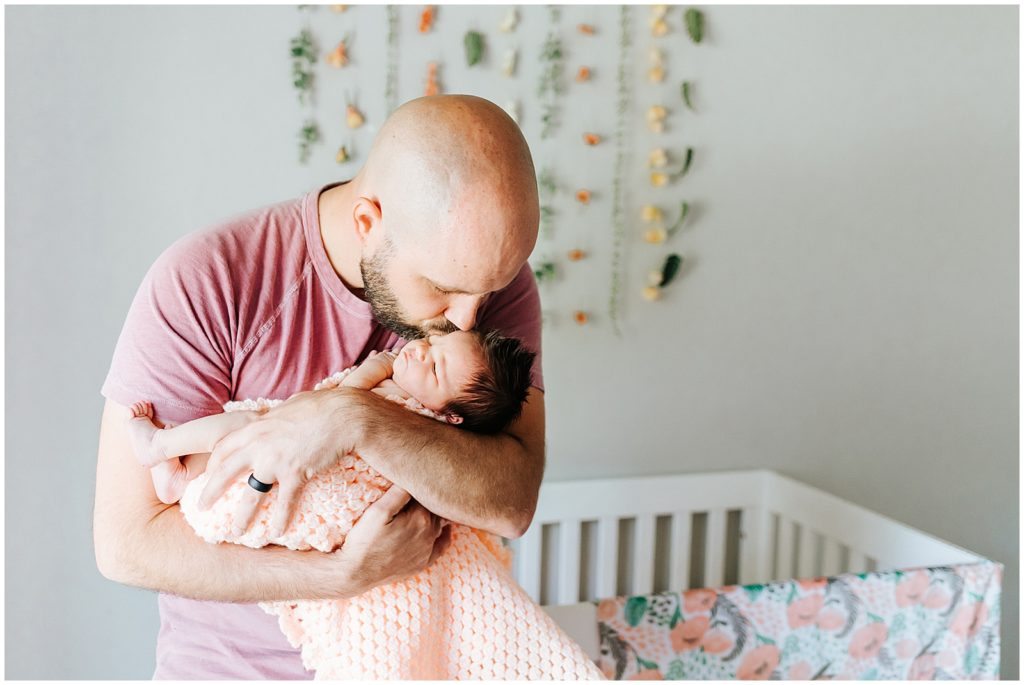 Dad kissing baby newborn in home lifestyle session
