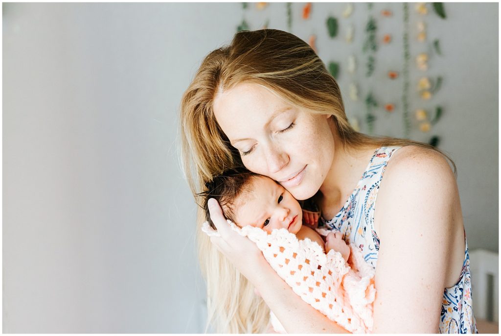 Newborn in home lifestyle mom cuddling baby