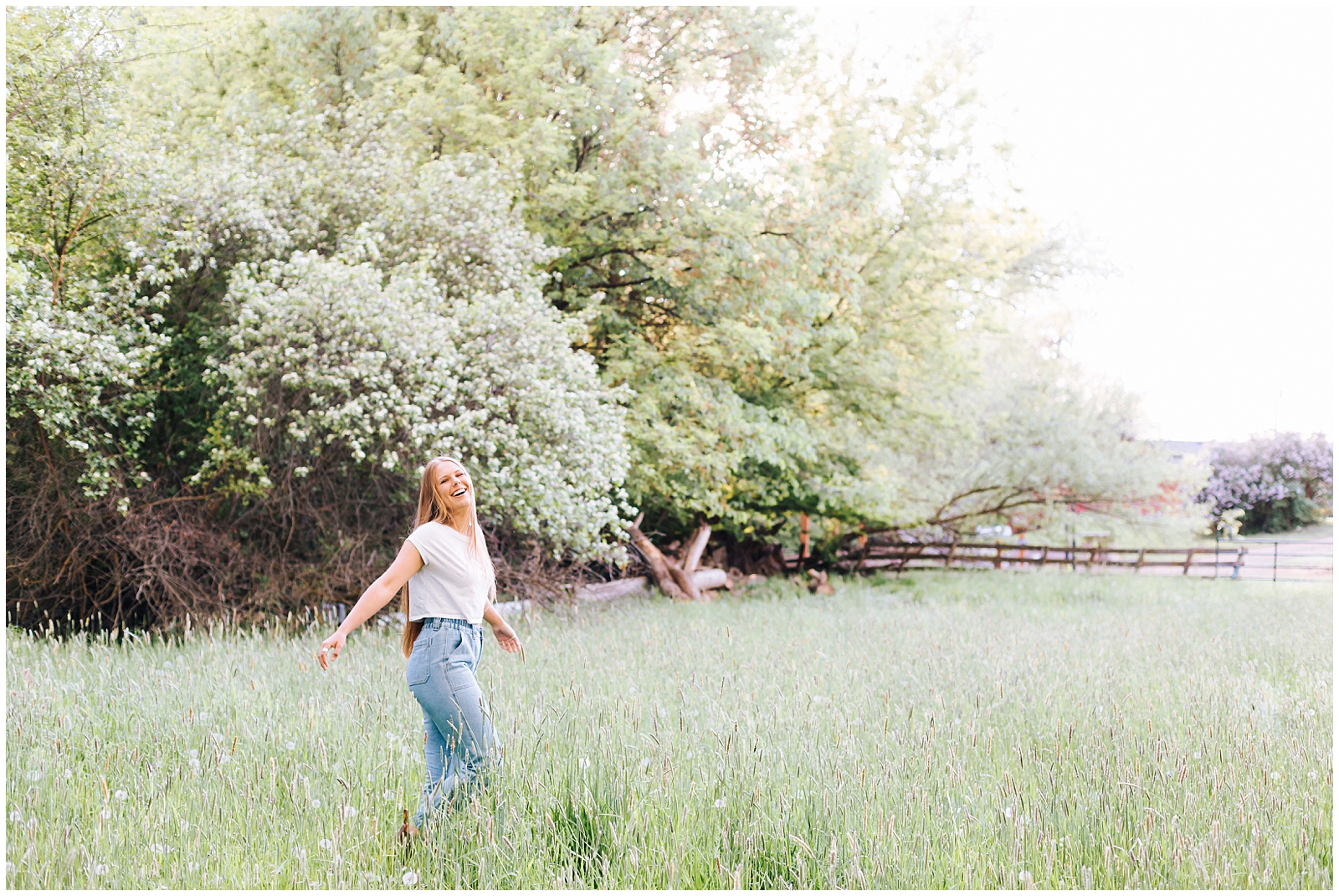 Senior Photos in Green Meadow with Rustic Fence