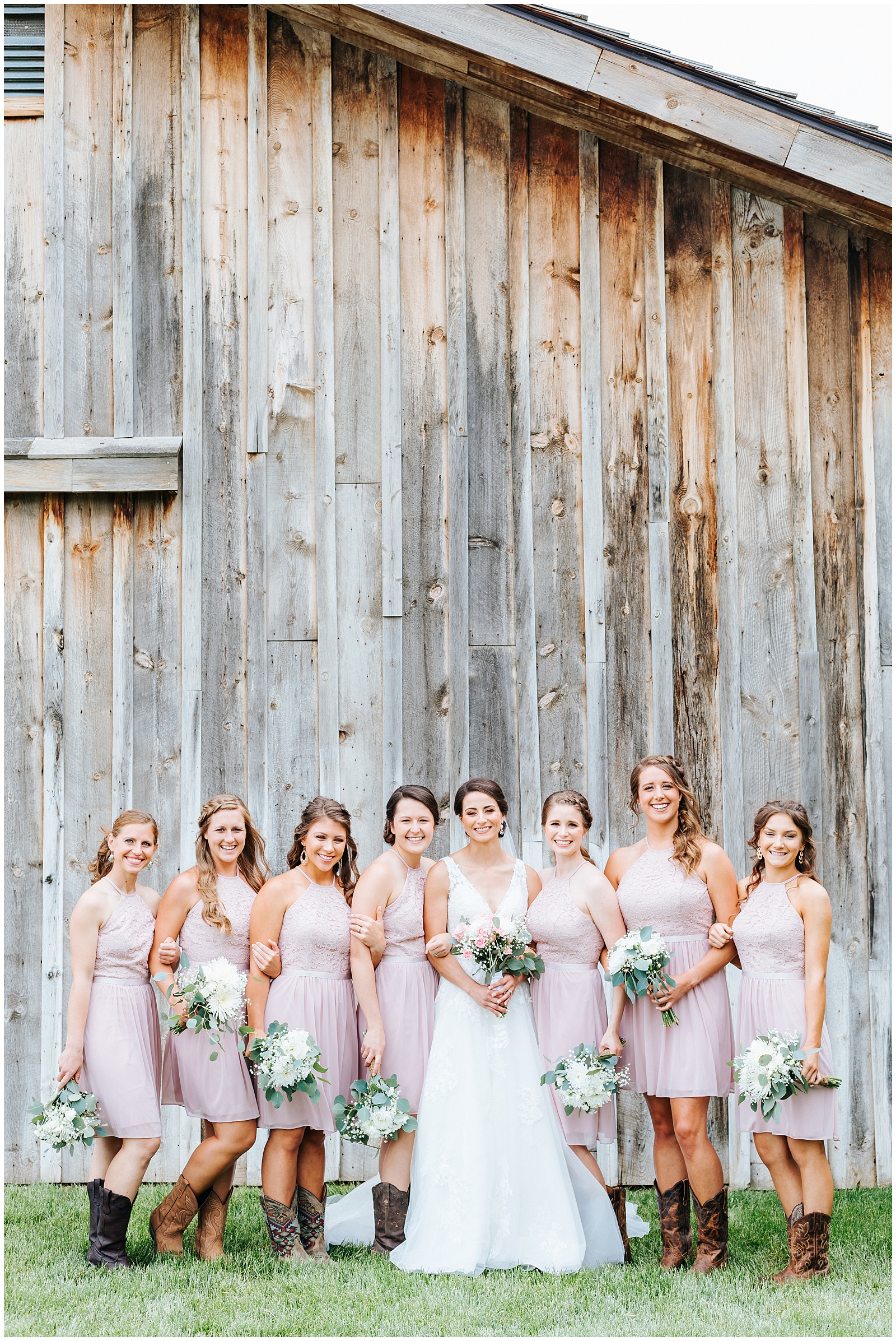 Bridesmaids in blush knee length dresses with cowboy boots