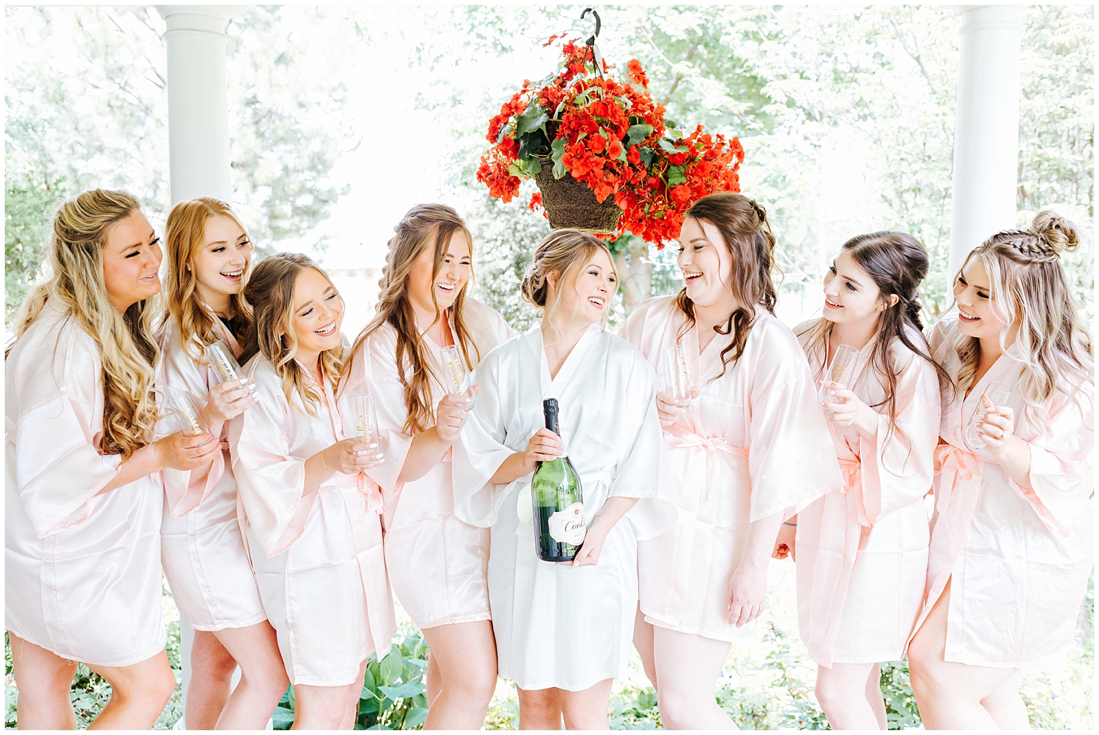 Bridal party matching robes popping champagne