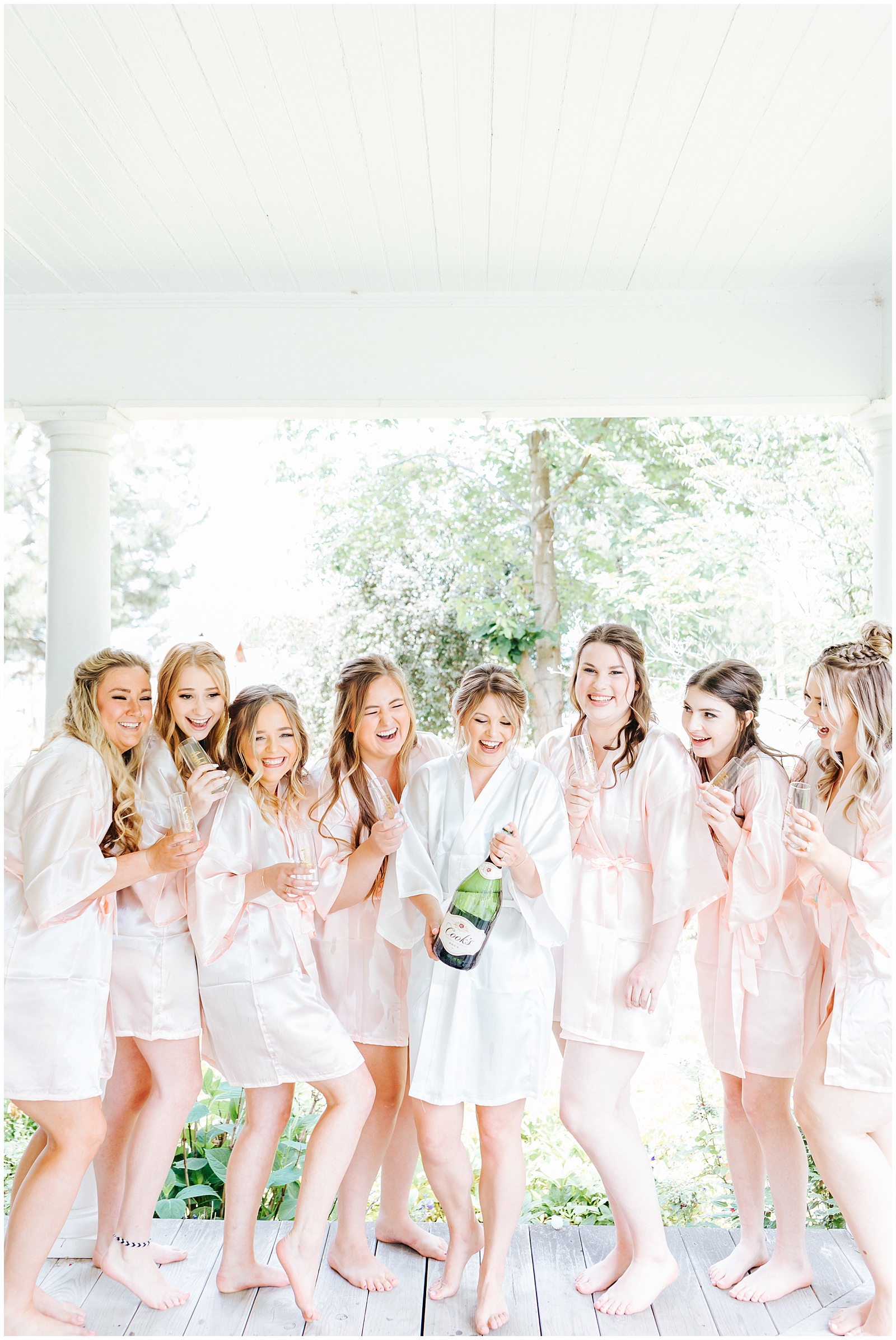 Fourth Street Gardens Wedding Bridesmaids in Blush robes popping Champagne