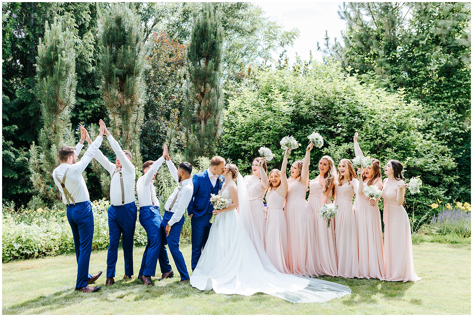 Bridal Party cheering as the Bride and Groom Kiss