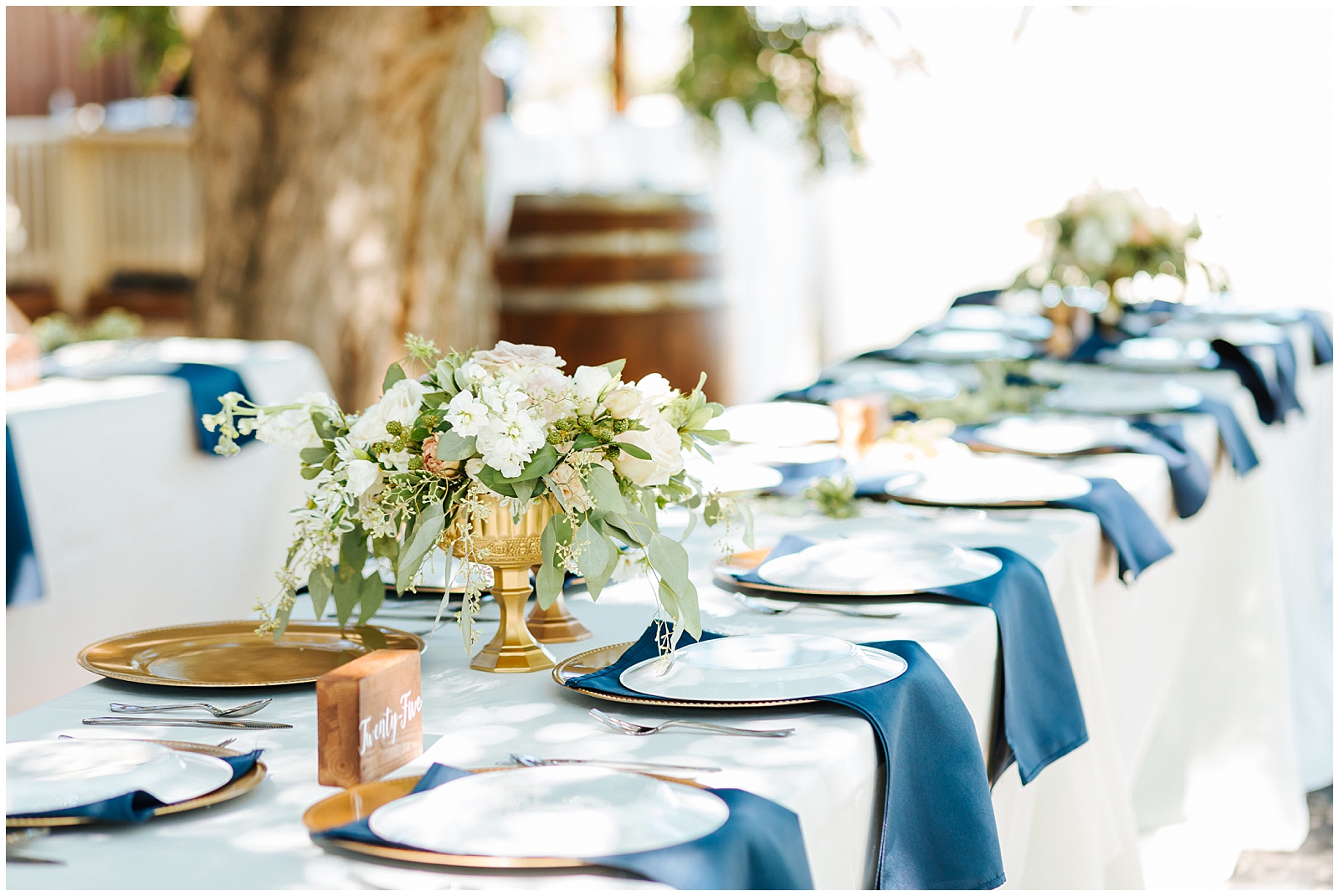 Tablescape with Navy Napkins, Gold Chargers, and Beautiful Floral Pieces