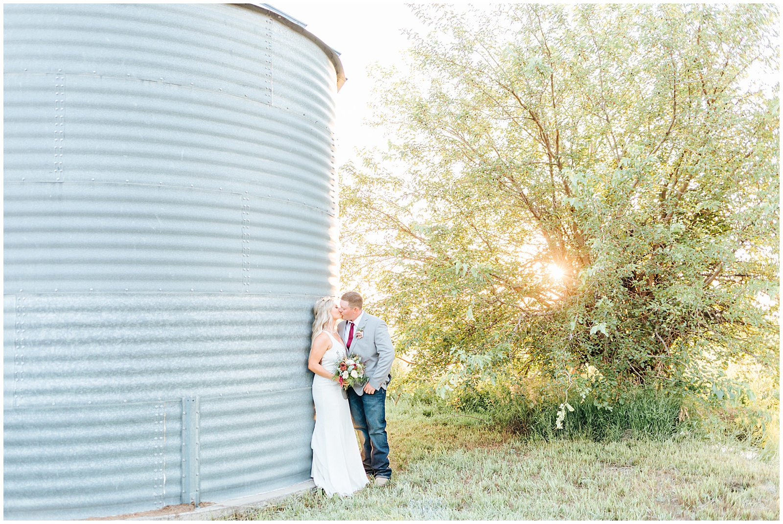 Wedding Portraits at Husband and wife Kissing against the Grain Bin Silos at Private Idaho Ranch Wedding