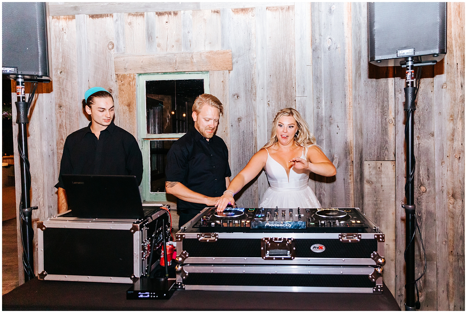 Bride jumping behind the DJ station at her wedding