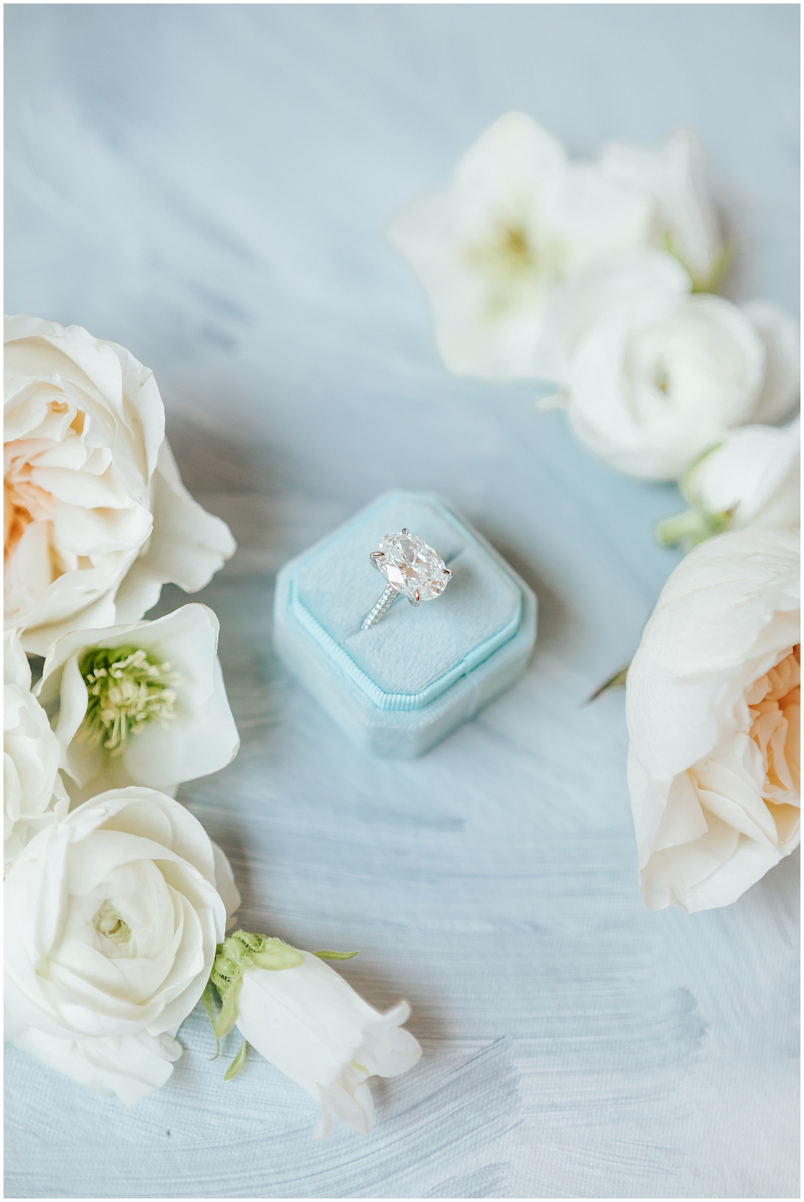 10 carat Engagement ring in dusty Blue Ring Box surrounded by Florals Wedding Flatlay