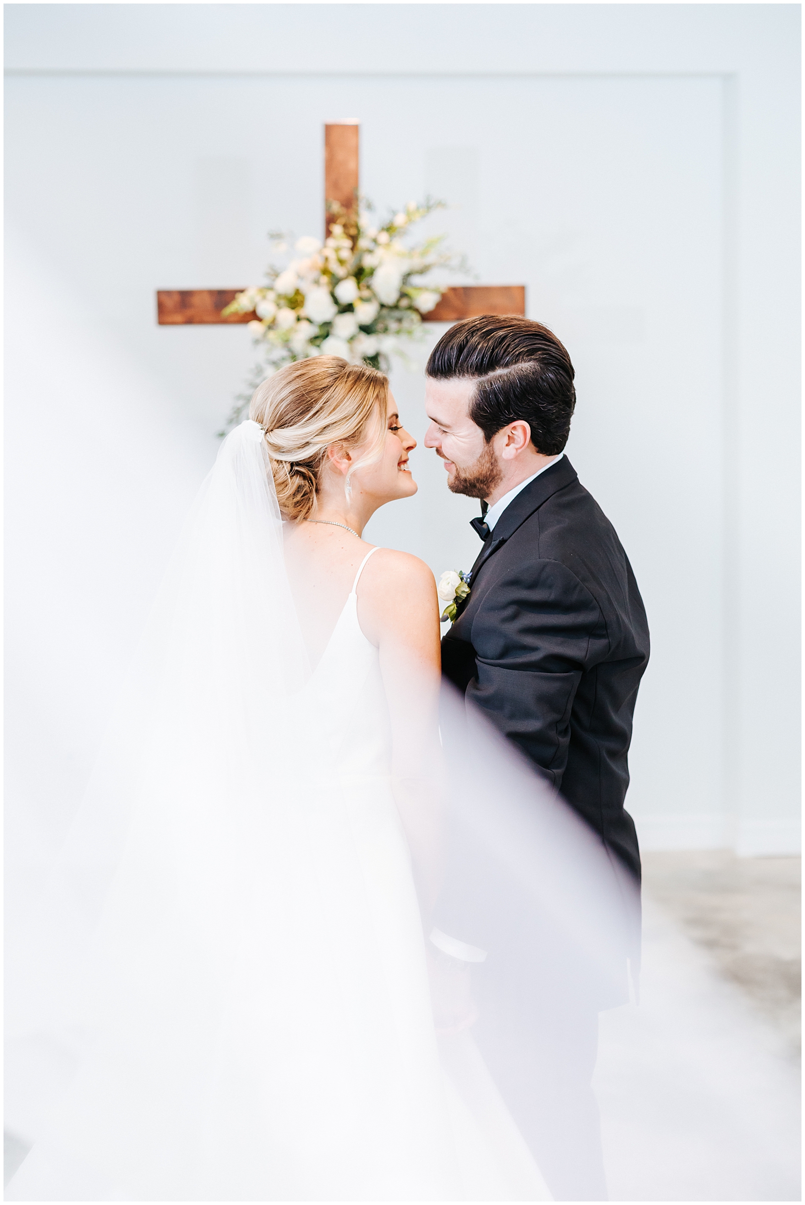 Bride and Groom with Veil Swooping behind sharing a sweet moment at Classic Elegant Florida Wedding